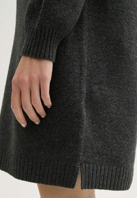 Donkergrijze wollen jurk met ribgebreide manchetten en zoom, voorzien van zijsplitten voor extra detail. Gemaakt van een gestructureerde, warme stof.