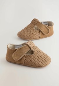 Bottines pour bébé en daim brun avec une texture tissée, dotées d'une fermeture par sangle et d'un bout rond. Matériau doux et flexible pour le confort.