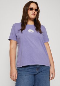 Purple cotton t-shirt with short sleeves and a crew neckline. Features a "MYSTIC" graphic print in white on the chest. Casual fit.