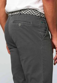 Gray trousers made of sturdy fabric, featuring a woven patterned belt in black and white, with buttoned back pocket detail.