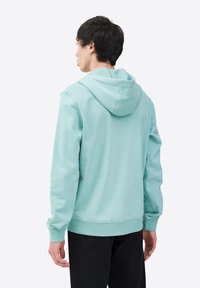 Sudadera verde menta hecha de una suave mezcla de algodón. Presenta un bolsillo tipo canguro, capucha ajustable con cordón y puños y dobladillo de canalé.
