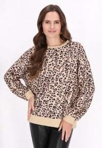 Pulover cu imprimeu leopard în nuanțe de bej și maro, cu guler rotund, mâneci lungi și manșete și tiv cântărite. Textură moale.