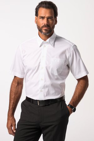 Mann mit Bart, der ein weißes kurzärmeliges Hemd trägt, das in schwarze Hose mit schwarzem Gürtel und Armbanduhr gesteckt ist.