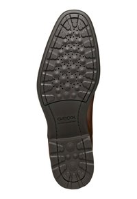 Suola di scarpa in gomma nera con un design testurizzato caratterizzato da motivi circolari e a forma di stella. Include il marchio "GEOX ULTRA COMFORT".