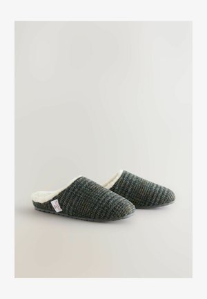 Wełniane klapki wsuwane o teksturowanym wzorze w ciemnozielonym i szarym kolorze, z białym puszystym wykończeniem i czarnymi gumowymi podeszwami zapewniającymi przyczepność.