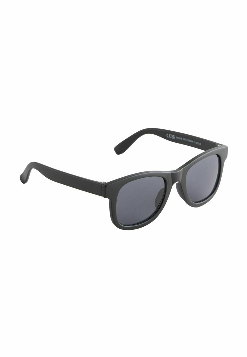 Lunettes de soleil noires avec une finition brillante, lentilles rondes et épais montures. Présente des branches courbées et un logo en relief sur la branche intérieure.