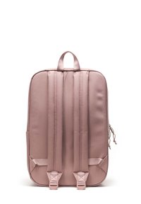 Mochila rosa con respaldo acolchado, correas ajustables, cierres de cremallera y bolsillos laterales. Textura suave con un diseño rectangular y sencillo.