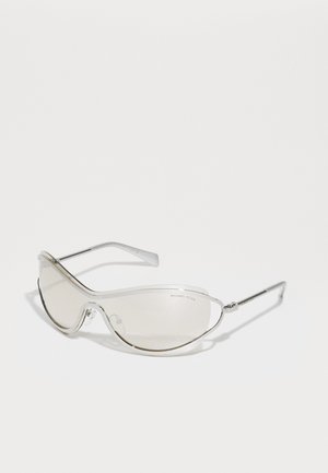 Occhiali da sole con montatura trasparente, lenti marroni chiaro, design elegante e curvato, e dettagli in metallo argentato sulle astine.