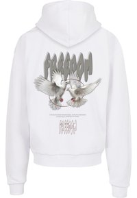 Hvid cropped hoodie med et grafisk billede af to flyvende duer over teksten "FREEDOM" i grå. Materialet ser blødt ud, med ribbede cuffe.