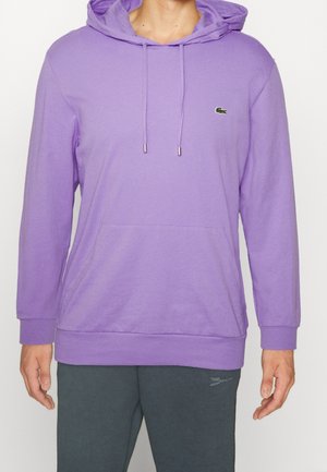 Lila Hoodie mit Kängurutasche, Kapuze mit Kordelzug und kleinem grünem Logo auf der Brust. Hergestellt aus weichem, leichtem Stoff.