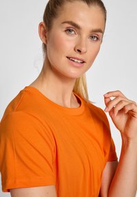 Oranje t-shirt van zacht katoen, met een ronde hals, korte mouwen en een gladde textuur, aangevuld met een eenvoudig ontwerp.
