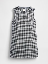 Robe sans manches à carreaux vichy bleu marine et blanc avec un col rond et des détails de boutons sur les deux épaules, posée à plat sur un fond blanc.