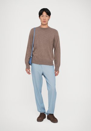 Brown knit sweater, light blue striped trousers, brown sneakers, and a blue crossbody bag. Simple design and casual fit.