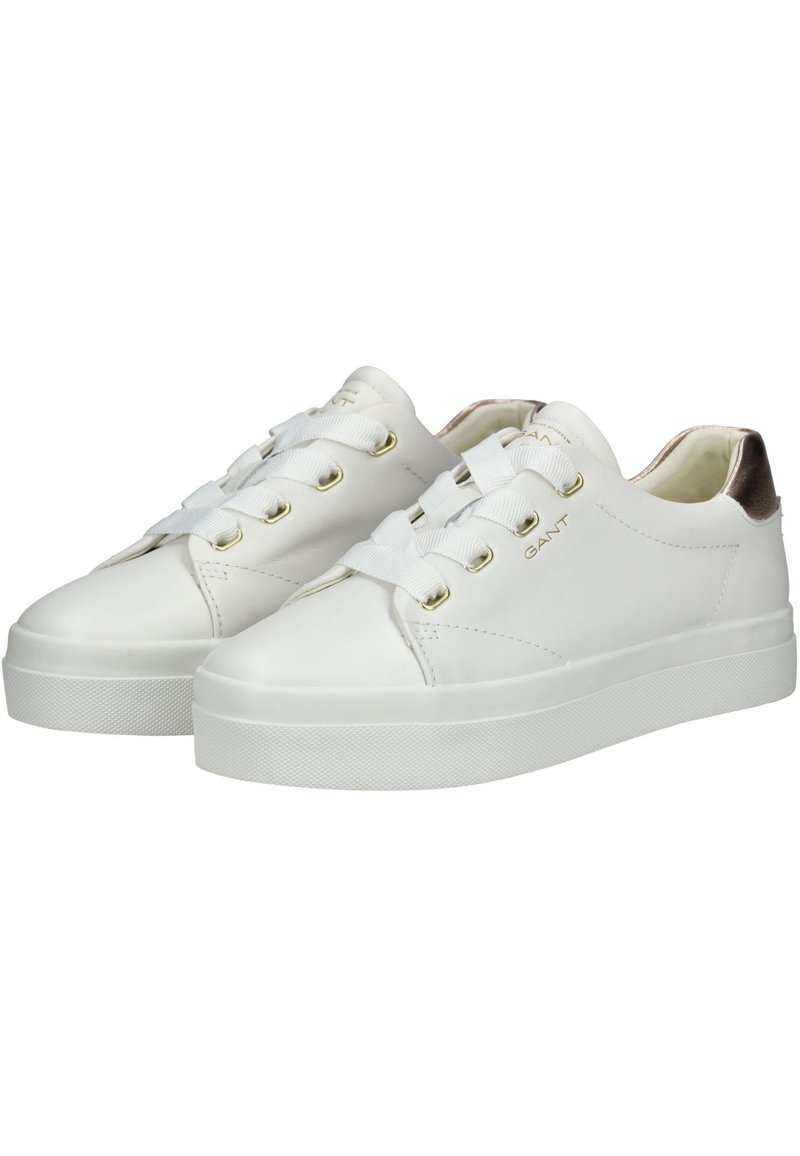 Baskets en cuir blanc avec une semelle texturée, des œillets dorés et un accent métallique au niveau du talon. Elles comportent des lacets plats et une pointe arrondie.