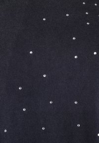 Čierny látkový top s rozptýlenými jasnými rhinestones rôznych veľkostí, ktoré vytvárajú textúrovaný, dekoratívny vzor na povrchu.