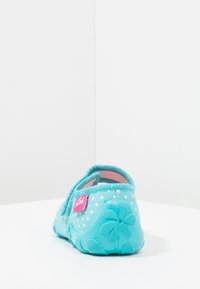 Lichtblauwe stoffen slipper met een gaasontwerp, witte stippen en een bloemmotief in de zool. Heeft een roze logo-label aan de zijkant.