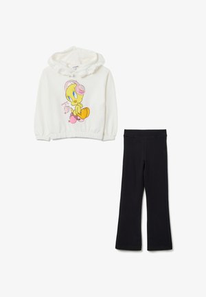 Sweat-shirt blanc à capuche avec un design de Tweety Bird et de cœurs roses, associé à un pantalon noir droit.