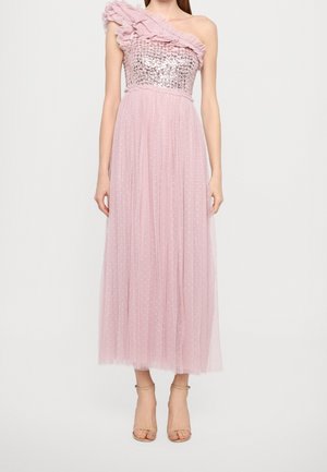 Vrouw in een roze jurk met één schouder, met een lijfje bezet met pailletten en een gerimpelde band, gecombineerd met naakte enkellaarsjes met bandje.