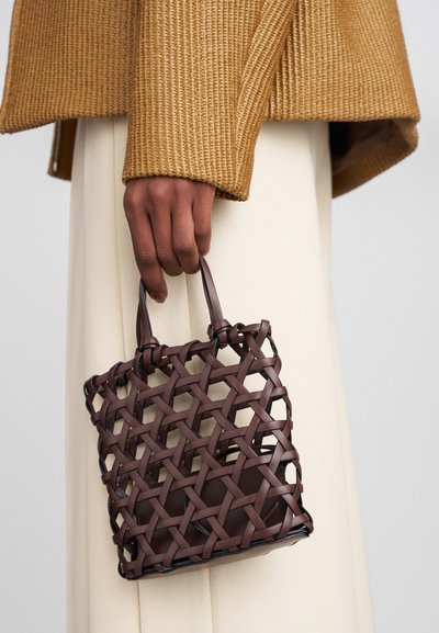 Brązowa pleciona torebka o kwadratowym kształcie, z charakterystycznym wzorem kratki i dwoma małymi uchwytami. Gładki, trwały materiał.