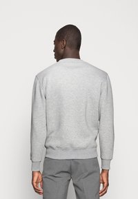 Grå sweatshirt lavet af et blødt materiale, med en klassisk rund hals, ribbede manchetter og kant, med en glat tekstur og et enkelt design.