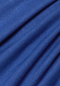 Niebieska tkanina pleciona o fakturowej powierzchni, ukazująca jednolity prążkowany wzór i gładkie wykończenie, składająca się na sobie.