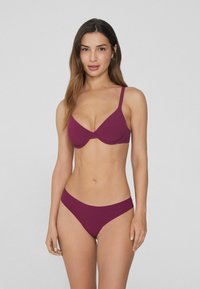 Bikini-Set in tiefem Burgunderrot. Enthält ein BH-ähnliches Oberteil mit verstellbaren Trägern und einen passenden, niedrig sitzenden Unterteil mit glatter Stofftextur.