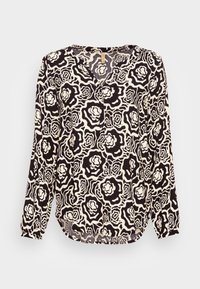 Blusa nera e crema con motivo floreale, maniche lunghe, scollatura a V e orlo leggermente curvo. Tessuto morbido e vestibilità rilassata.