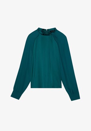 Mėlyna bluzonė ilgomis rankovėmis, aukštu kaklu ir klostuotu priekiniu detaliu. Lygi, satino tipo medžiaga su subtiliu blizgesiu ir užtrauktuku gale.