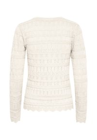 Valge kudum, millel on keeruline pitsdetail, pikad varrukad, ümmargune kaelus ja laineline äär. Kudu mustrid kogu pulli ulatuses.