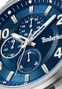 Timberland laikrodis su tekstūruotu mėlynu ciferblatu, sidabriniais akcentais, trimis subdalykais ir ryškiais valandų žymenimis. Savybės: nerūdijančio plieno korpusas ir rankenėlės.