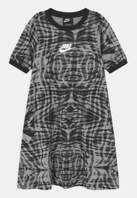 Sukienka o krótkich rękawach do kolan w szarym kolorze z czarnym wzorem w paski tygrysa. Posiada czarny okrągły dekolt i subtelne logo Nike.