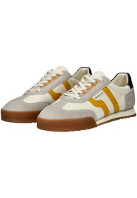 Sneaker in una combinazione di colori crema, grigio e giallo. Realizzati in camoscio e pelle con suole in gomma. Presentano strisce e lacci a contrasto.