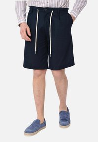 Pantaloni corti blu navy con una vita regolabile e lacci in corda. Realizzati in tessuto leggero, presentano un design a taglio dritto. I dettagli includono un bottone.