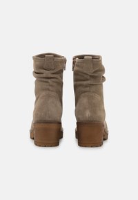 Braune Wildleder-Ankle-Boots mit lässigem Design, Rückenzipper und gestapeltem Holzabsatz. Strukturierter Stoff mit weicher Oberfläche.