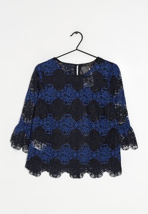 Zwart en blauw kanten blouse met bloemenpatroon, driekwart mouwen, geschulpte randen, hangend aan een zwarte kledinghanger tegen een witte achtergrond.