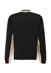 Svart jacka med vit innervadding, röda sidostråk, elastiska ärmslut och en randig krage. Slät tyg och lätt design.