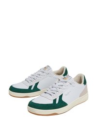 Bele superge bele barve z zelenimi semena iz usnja, gladka usnjena zasnova, ravne vezalke in gumijast podplat z logotipom na strani.