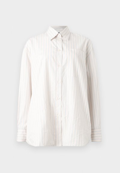 Λευκό πουκάμισο με μακριά μανίκια, λεπτές κάθετες πορτοκαλί ρίγες και μία τσέπη στο στήθος, σε μονόχρωμο φόντο.