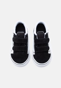 Μαυρόασπρα παπούτσια για νήπια από σουέτ και καμβά. Διαθέτουν διπλό λουράκι με βέλκρο, στρογγυλή μύτη και επάνω μέρος με υφή.