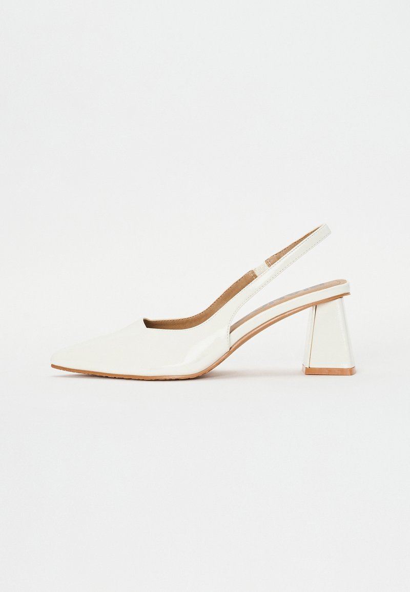 Soulier slingback en cuir verni blanc avec un bout pointu et un talon mi-hauteur épais et évasé sur fond blanc.