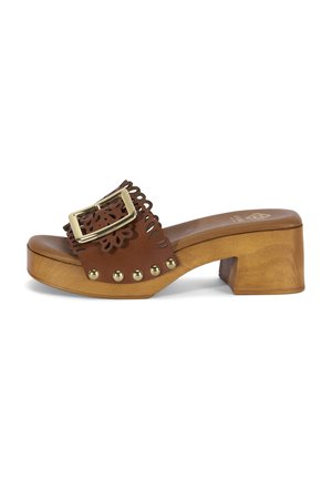 Sandale à enfiler en cuir marron avec talon bloc en bois, grande boucle dorée, bords festonnés et clous métalliques décoratifs le long de la semelle.