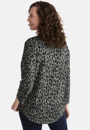 Green top with black leopard print, made from soft fabric. Features a relaxed fit, rounded hem, and 3/4 sleeves.