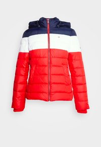 Doudoune avec capuche, présentant des blocs de couleurs rouge, blanc et bleu marine. Le matériau est brillant avec des coutures horizontales, une fermeture éclair et des poches latérales.