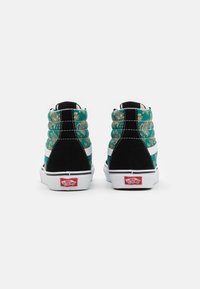 Vysoké tenisky s tyrkysovým květinovým vzorem, černou semišovou patou, bílými bočními pruhy a červeným logem Vans na patě.