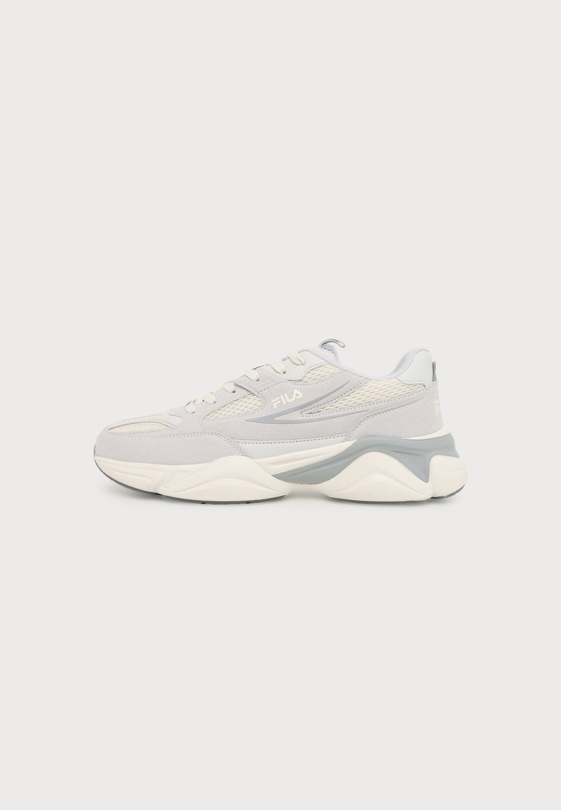 Ανοιχτό γκρι και λευκό sneaker FILA με λεπτομέρειες από δίχτυ και σουέτ, παχιά σόλα με γκρι ακρομαντήρι, εμφανίζεται από το πλάι σε μονόχρωμο φόντο.