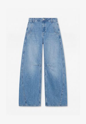 Jean large bleu clair à taille haute, avec poches avant et coutures visibles sur les genoux et les côtés.