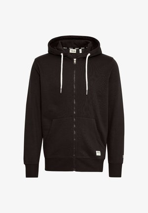 Svart hettejakke med glidelås laget av myk stoff, med snorhette, to frontlommer og kontrasterende hvite detaljer for glidelåsen og snorene.