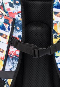 Wielokolorowy plecak z wyściełaniem, posiadający wzorzysty zewnętrzny materiał z różnorodnymi, żywymi obrazkami. Zawiera czarną siateczkową plecy oraz regulowane paski.