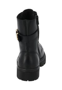 Bottine en cuir noir avec fermeture éclair, bout rond, semelle texturée et accent de boucle sur le côté. Finition lisse avec col rembourré.