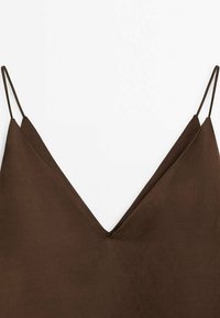 Brązowa, bezrękawnikowa sukienka z dekoltem w kształcie litery V, wykonana z gładkiego materiału. Cienkie ramiączka i krój w literę A. Bez widocznych wzorów i ozdób.